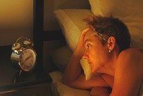 sleepless woman looks at alarm clock (from Stress Express book)